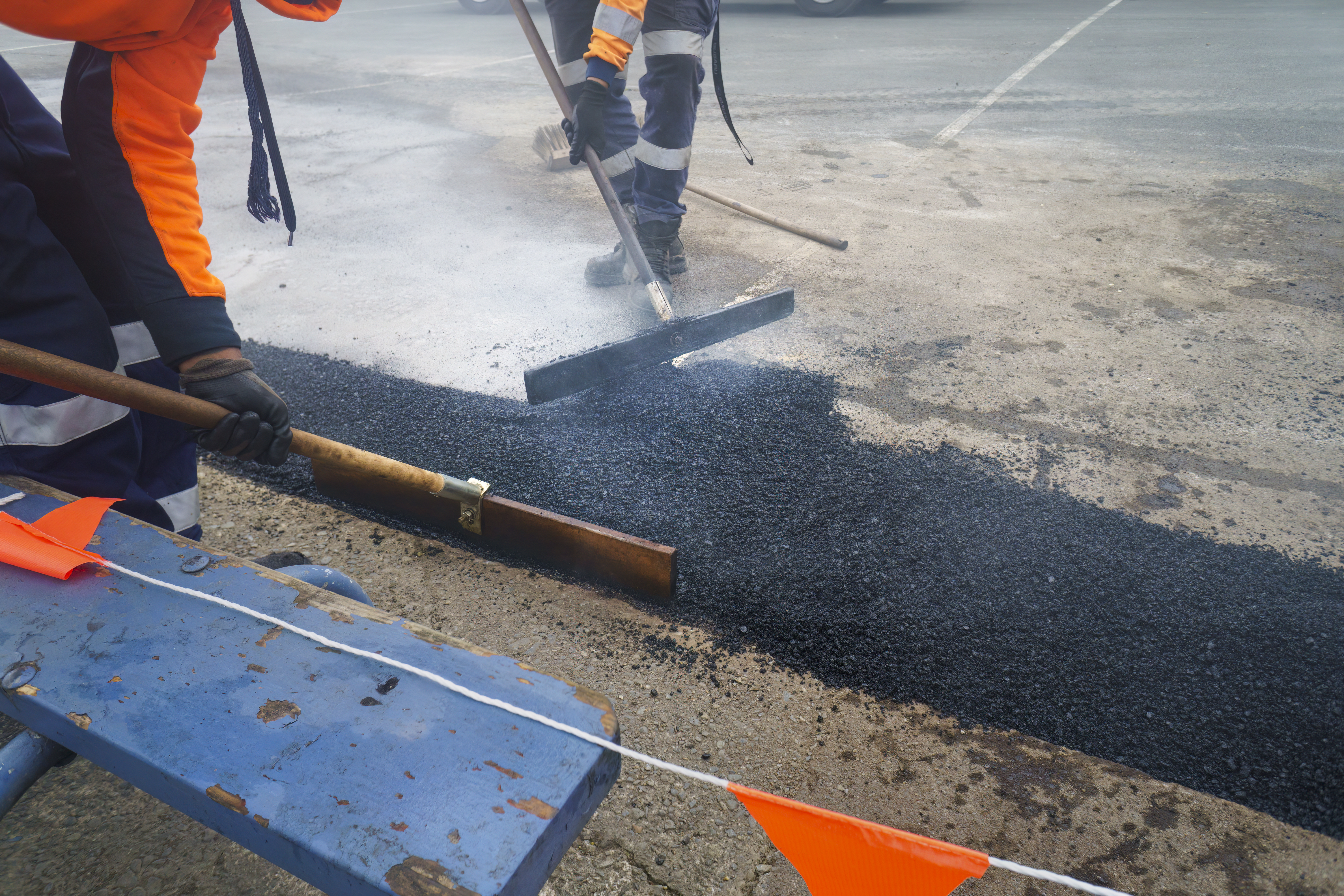 Road resurfacing. Fresh asphalt construction. Workers repairing the road. Auckland.
